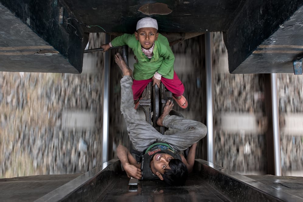 Free Riders: Stromschläge, angetrennte Gliedmaßen oder Zusammenstöße mit Tunneln – Das hindert "Zugreiter" jedoch nicht daran, auf fahrende Züge zu springen. In Bangladesch ist das eine weit verbreitete Form des Transports.