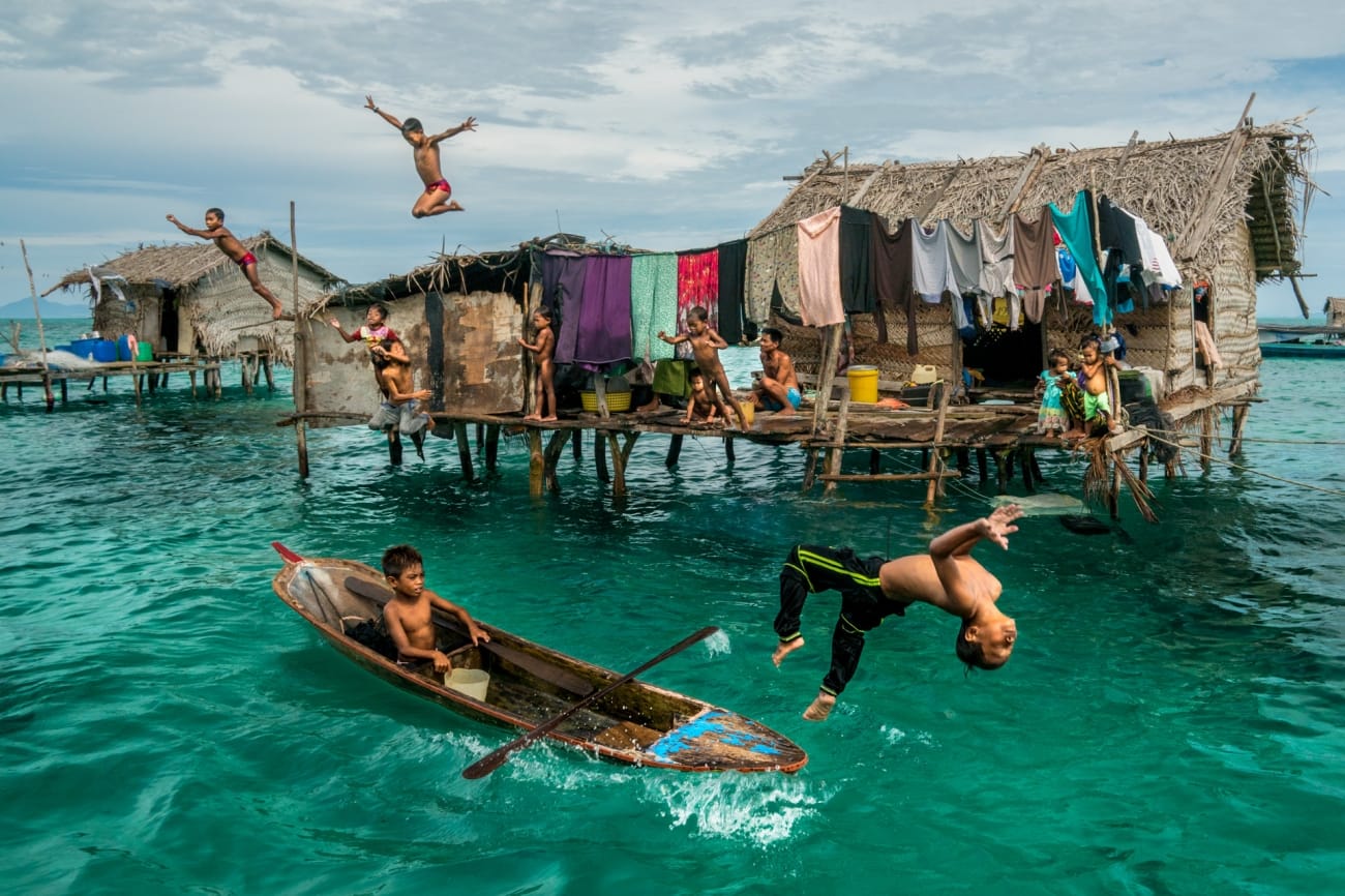 Malaysia: Ein kleiner Junge springt fröhlich vom Boot ins Wasser.