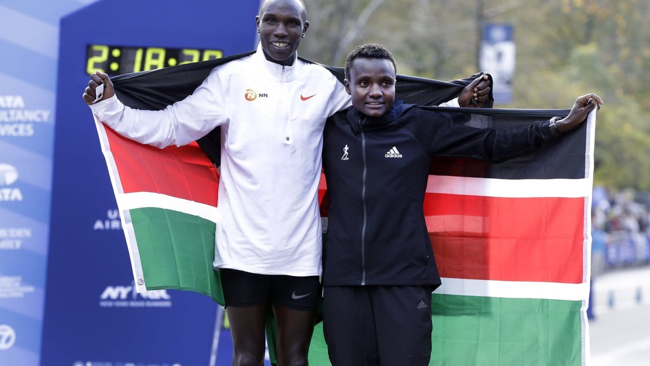 Die Kenianer Geoffrey Kamworor und Joyciline Jepkosgei posieren während der Siegerehrung mit den Landesfarben.