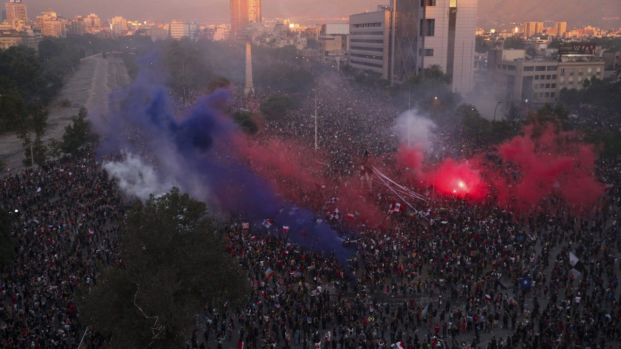 Rauchwolken von Fackeln steigen über einer riesigen Demonstration in Santiago de Chile auf.