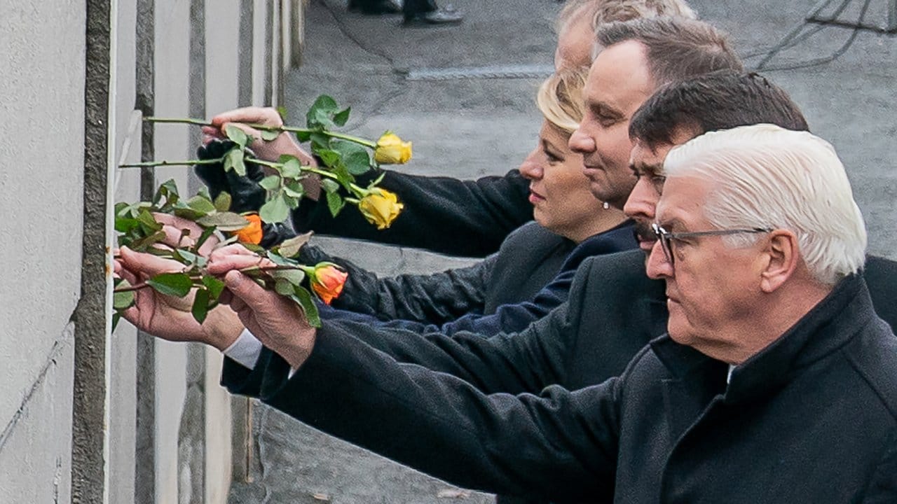 Bundespräsident Frank-Walter Steinmeier (r-l), und die Präsidenten Janos Ader (Ungarn), Andrzej Duda (Polen), Zuzana Caputova (Slowakei) und Milos Zeman (Tschechien) stecken Blumen in die Hinterlandmauer.