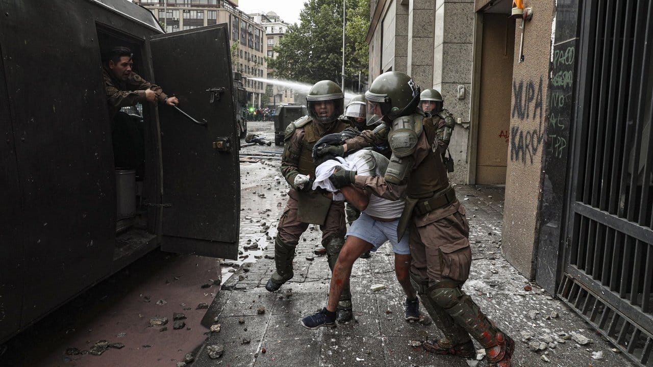 Polizisten verhaften einen Demonstranten: Die gewalttätigen Ausschreitungen in Chile nehmen kein Ende.