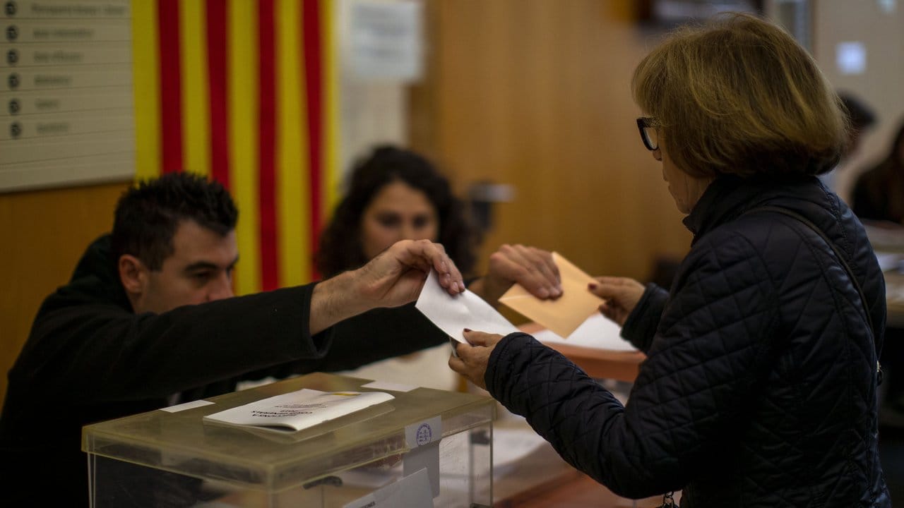 Zum zweiten Mal in diesem Jahr: Eine Wählerin nimmt in Barcelona ihren Stimmzettel für die Parlamentswahl entgegen.