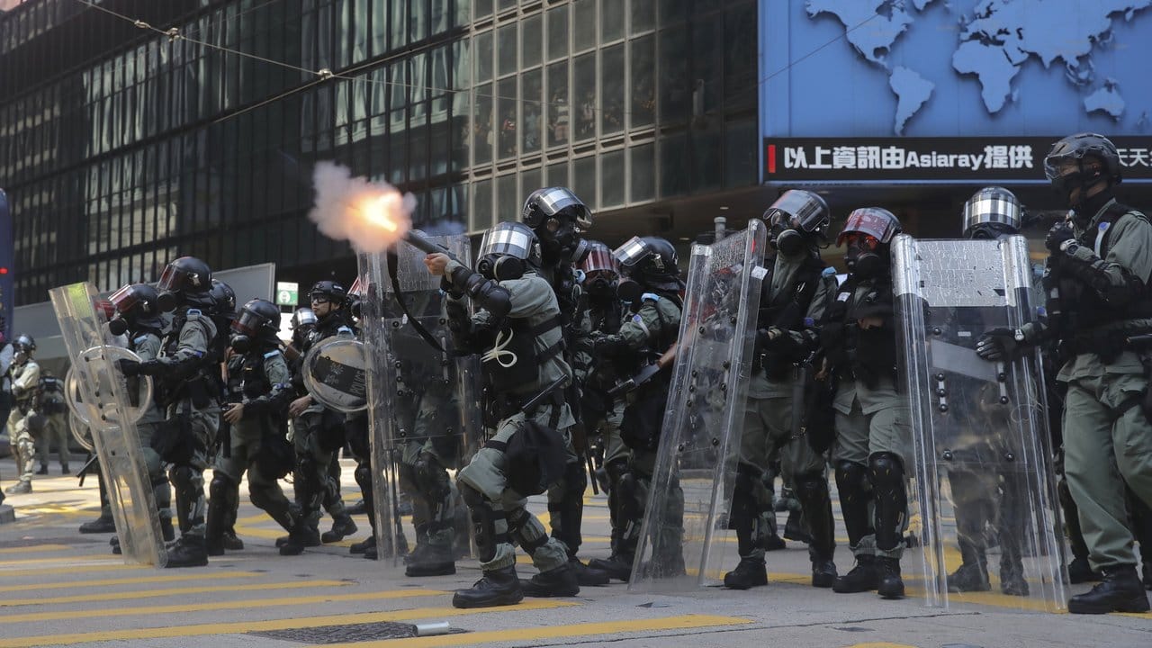 Ein Polizist feuert mit Tränengas.