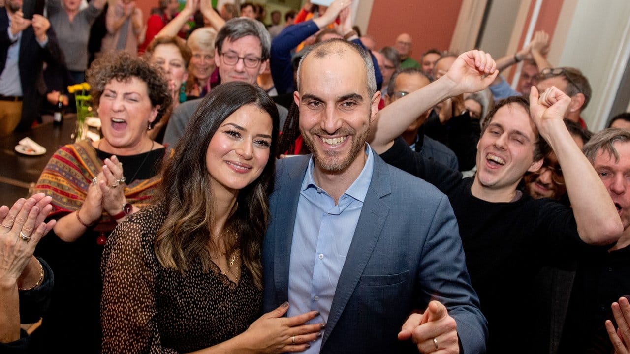 Belit Onay (Bündnis 90/Die Grünen), Spitzenkandidat bei der Oberbürgermeisterwahl, freut sich mit seiner Frau Derya (l) und seinen Unterstützern nach Bekanntgabe der Wahlergebnisse.