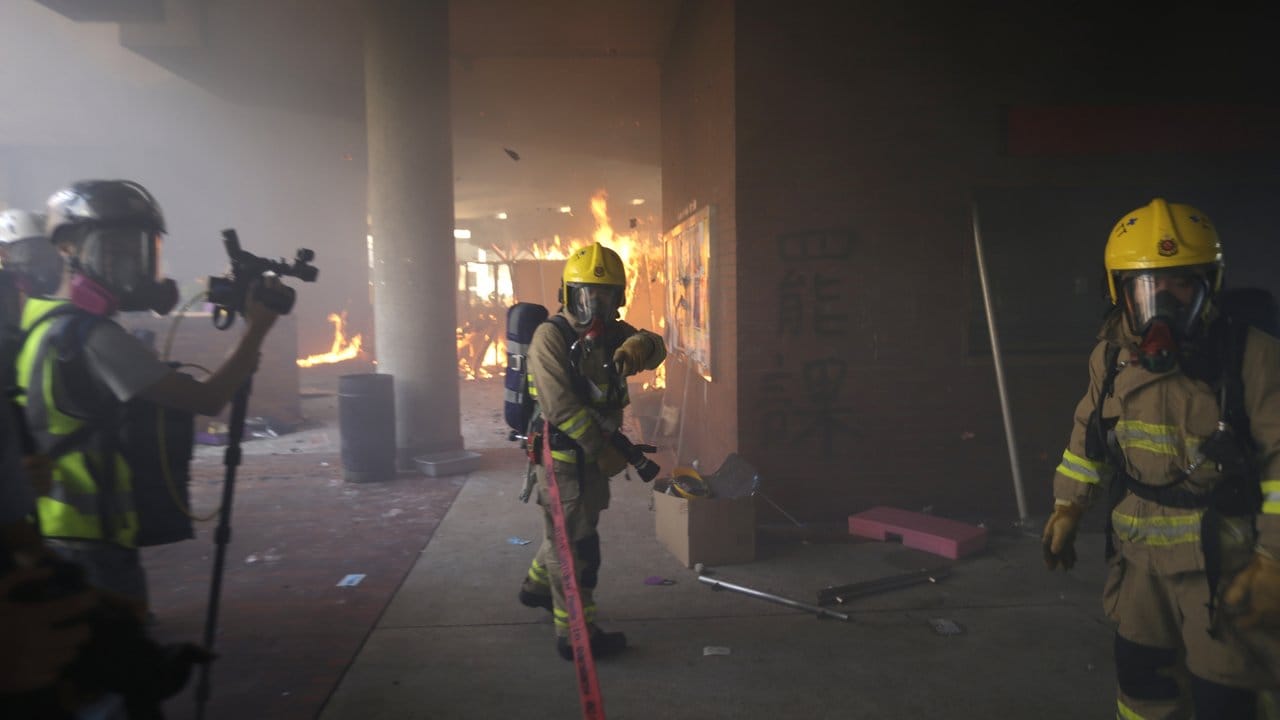 Feuerwehrleute versuchen ein von Demonstranten ausgelöstes Feuer in der Polytechnischen Universität zu löschen.