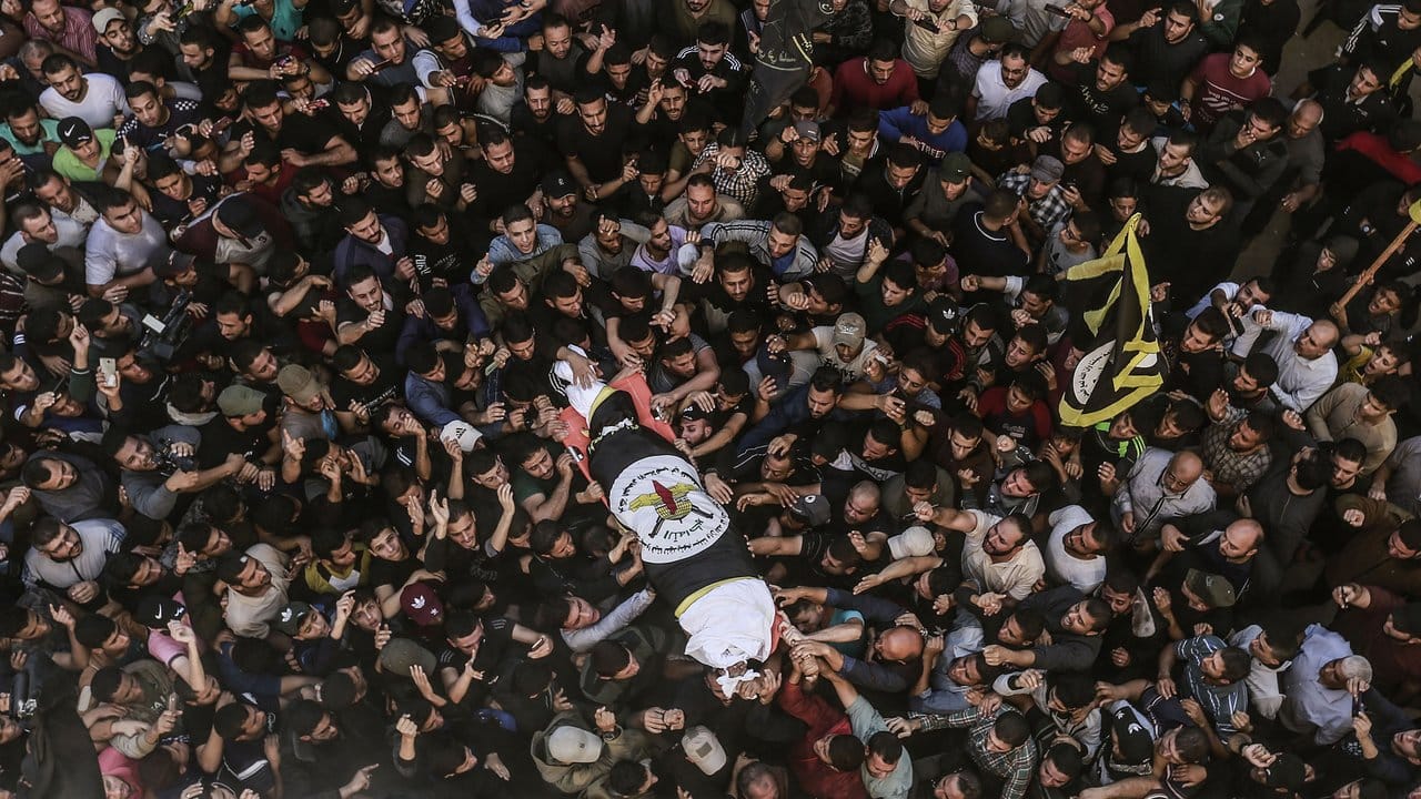 Eine Menschenmenge trägt den eingewickelten Körper von Dschihad-Militärchef Baha Abu Al Ata in Gaza-Stadt zu Grabe.