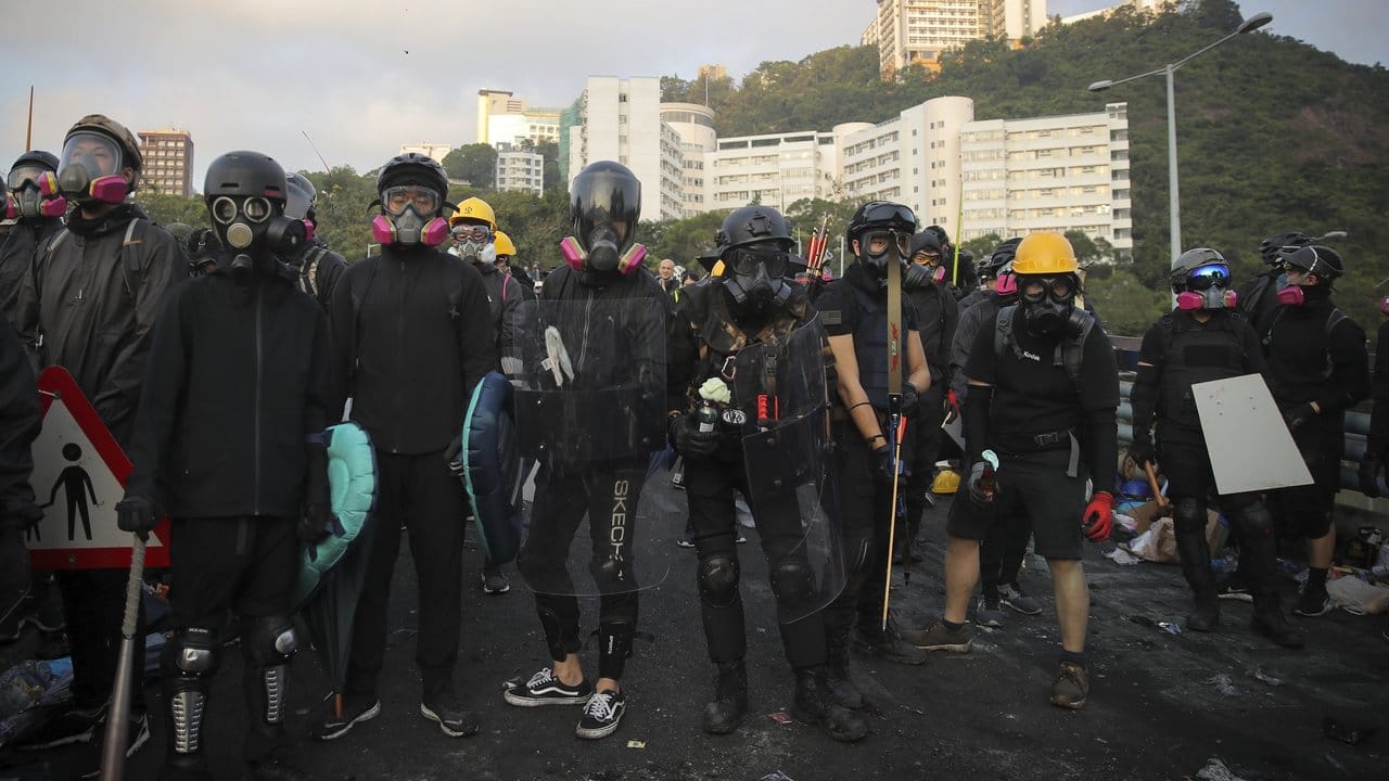 In Kampfmontur: Bewaffnete Studenten mit selbstgebauten Atemmasken vor eines Universität in Hongkong.