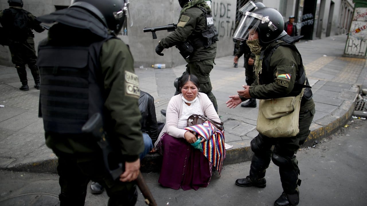 Eine Morales-Unterstützerin wird in La Paz von Polizisten umringt.