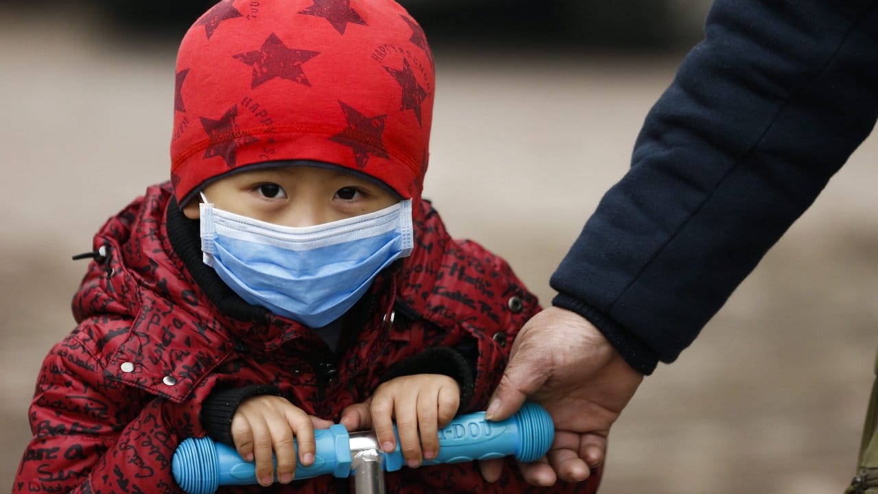 Ein Kind in Peking trägt zum Schutz vor Smog eine Atemmaske.