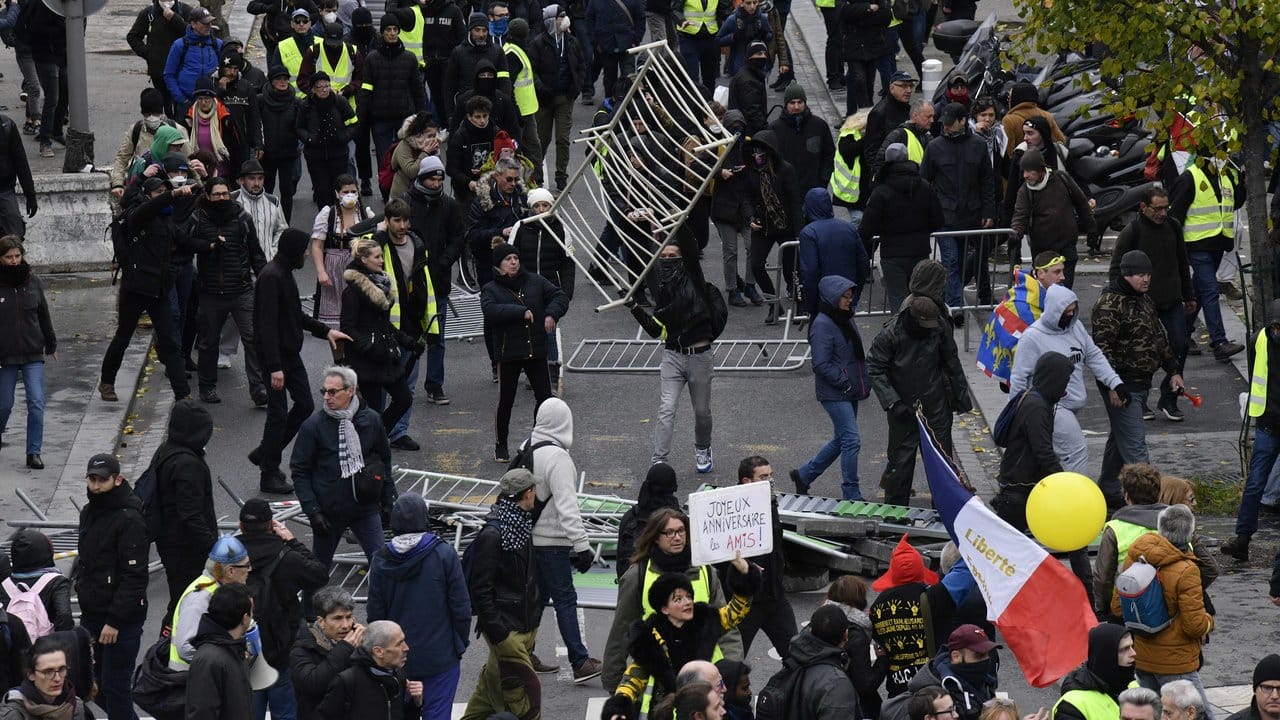 Demonstranten haben in Paris Absperrgitter umgestoßen.