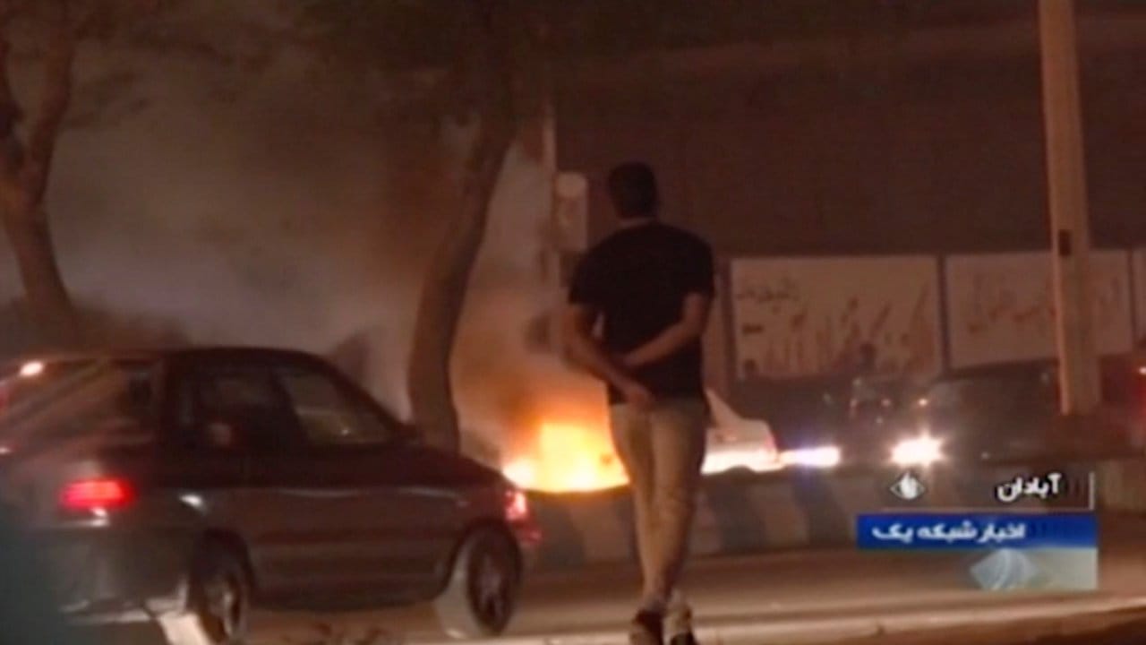 Das Videostandbild, das die staatliche Rundfunkgesellschaft der Islamischen Republik Iran zur Verfügung gestellt hat, geht ein Mann an einem Feuer vorbei, das von Demonstranten in Abadan gelegt wurde. Das Videostandbild, das die staatliche Rundfunkgesellschaft der Islamischen Republik Iran zur Verfügung gestellt hat, geht ein Mann an einem Feuer vorbei, das von Demonstranten in Abadan gelegt wurde.