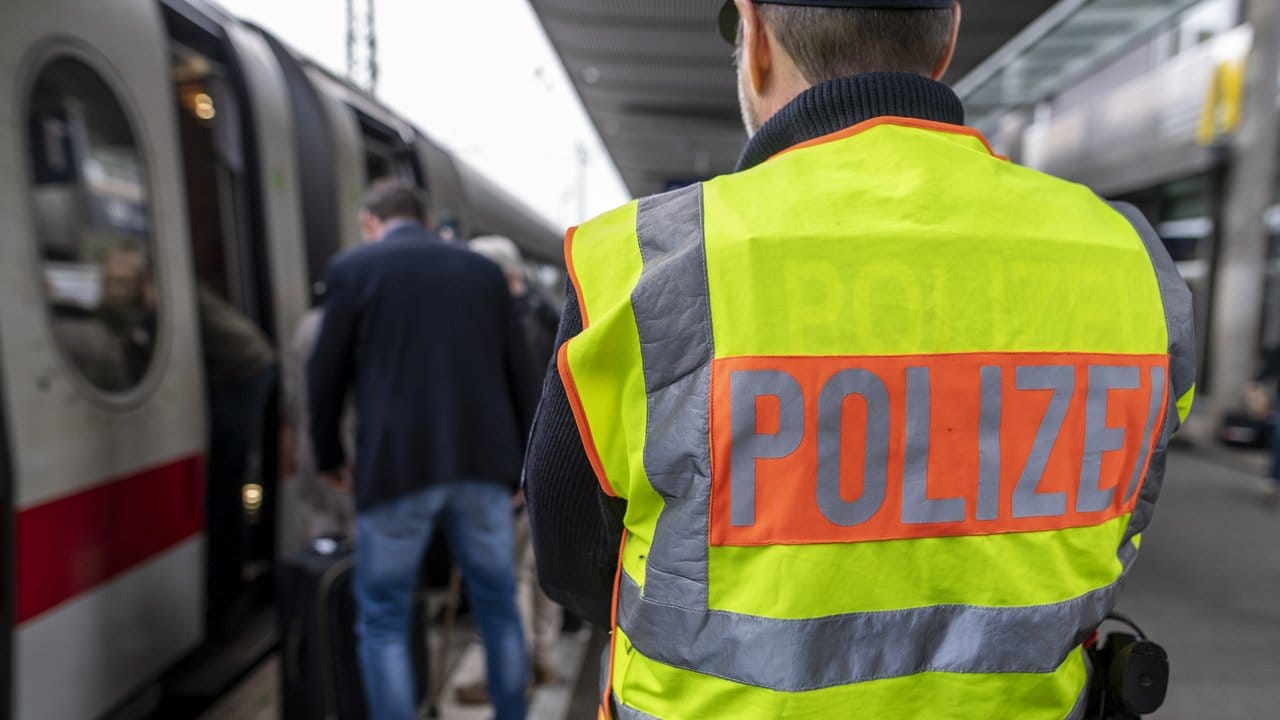 Ein Beamter der Bundespolizei beobachtet am Hauptbahnhof den Einstieg von Passagieren in einen ICE.