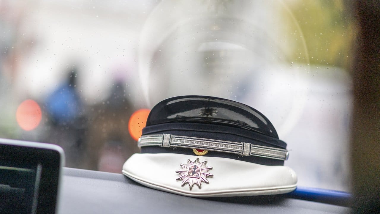Eine Mütze eines Bundespolizisten liegt auf einem Armaturenbrett.