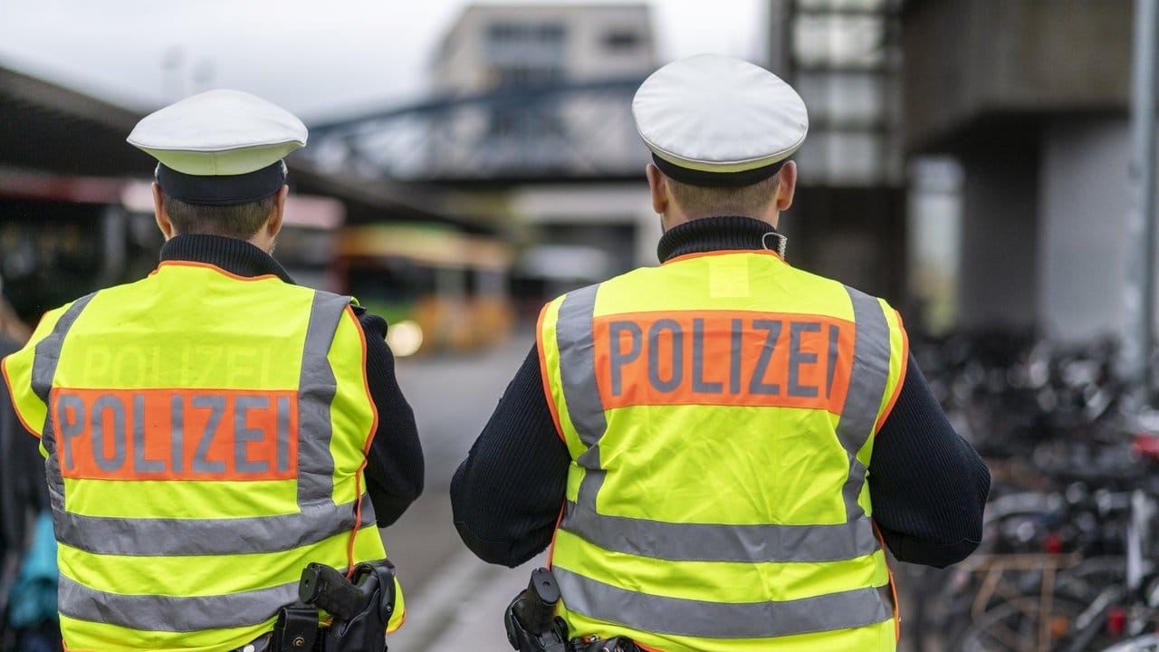 Zwei Bundespolizisten stehen am Hauptbahnhof und beobachten Busse bei der Einfahrt zum Busbahnhof.