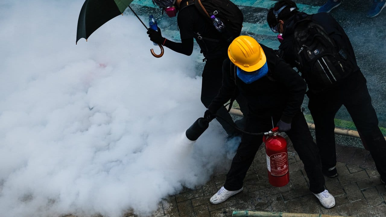 Demonstranten bekämpfen Tränengas mit einem Feuerlöscher.