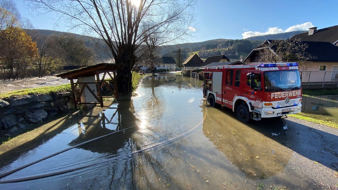Ein Feuerwehrfahrzeug steht auf einer überfluteten Straße in Kärnten.