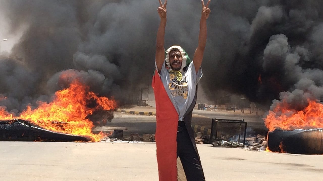 Ein Demonstrant steht in der Nähe des Armeehauptquartiers in der sudanesischen Hauptstadt Khartum vor brennenden Barrikaden.