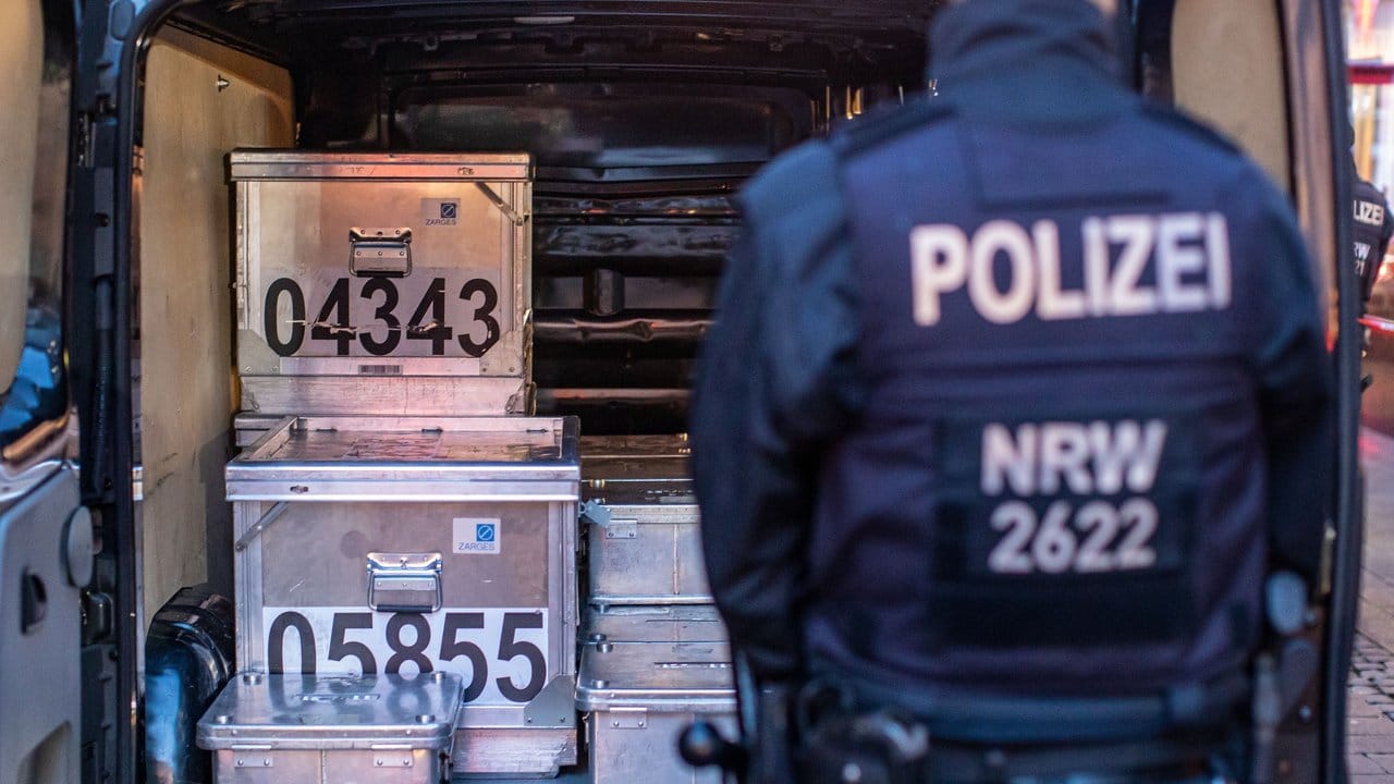 Polizeibeamte sichern kistenweise Beweise nach einer Durchsuchung in einem Geschäft. Polizeibeamte sichern kistenweise Beweise nach einer Durchsuchung in einem Geschäft.