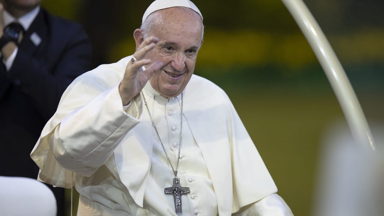 Papst Franziskus begrüßt Gläubige bei seiner Ankunft zur Messe im Nationalstadion.