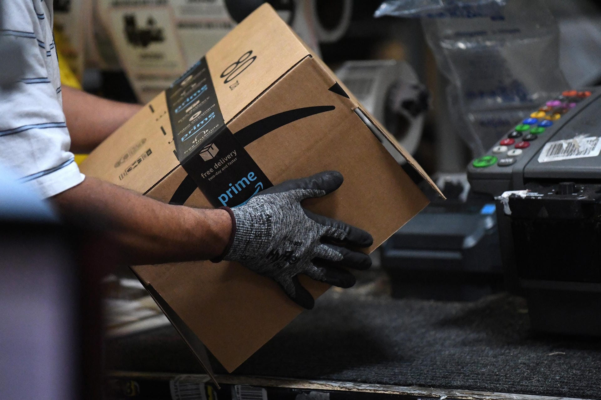 Ein Amazon-Mitarbeiter bearbeitet ein Paket.