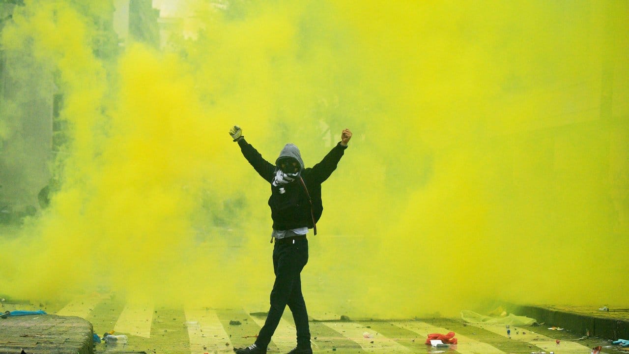 Ein Demonstrant reißt in der Innenstadt von Bogota während eines landesweiten Streiks die Arme hoch.