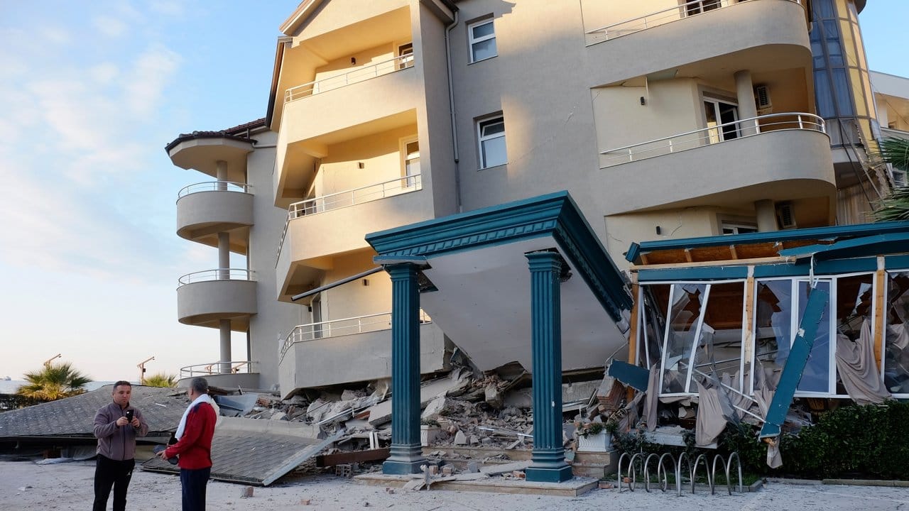Nach dem Erdbeben stehen zwei Männer neben einem beschädigten Gebäude in Durres.