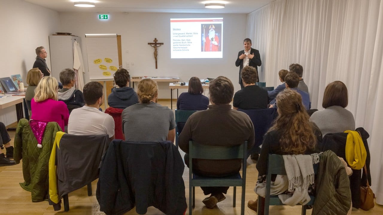 Teilnehmer einen Kurses für ein "Nikolaus-Diplom" hören in einem Seminarraum Andreas Steinhauser, Jugendseelsorger aus Landshut, bei seinem Vortrag zu.