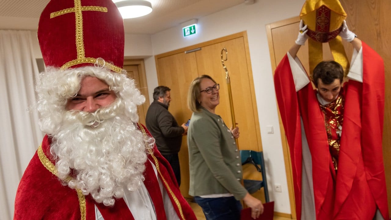 Teilnehmer einen Kurses für ein "Nikolaus-Diplom" ziehen sich in einem Seminarraum ihre Kostüme an.