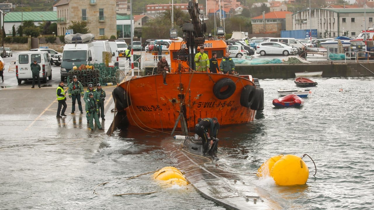 Ein Schlepper der Guardia Civil zieht ein gut 20 Meter langes Drogen-U-Boot aus dem Wasser, das vor der Küste der Region Galicien abgefangen worden war.