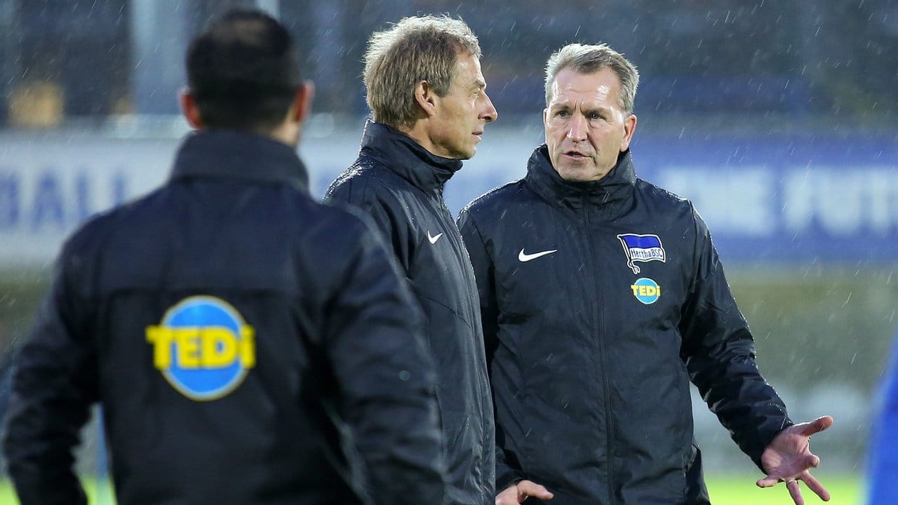 Erstes Training nach dem Trainerwechsel: Jürgen Klinsmann steht mit Torwartcoach Andreas Köpke (r) im Regen auf dem Spielfeld.