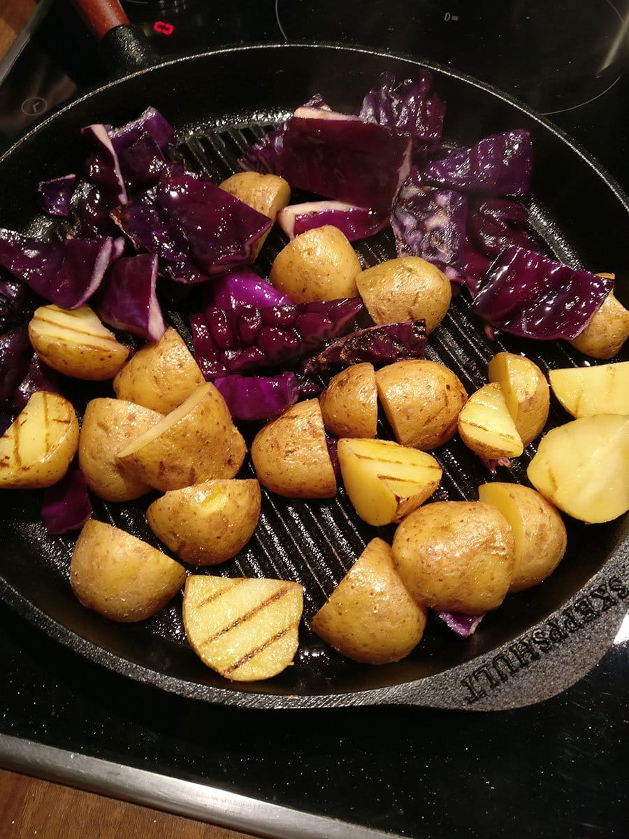 Braten Sie die Kartoffeln und den Kohl nun in einer Grillpfanne mit etwas Öl an: bei mittlerer Hitze für circa zehn Minuten. Dann zur Seite stellen.