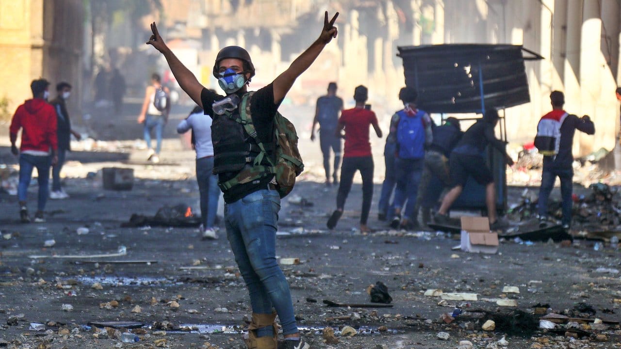 Ein regierungskritischer Demonstrant in Irak zeigt bei Zusammenstößen mit der Polizei das Victory-Zeichen.