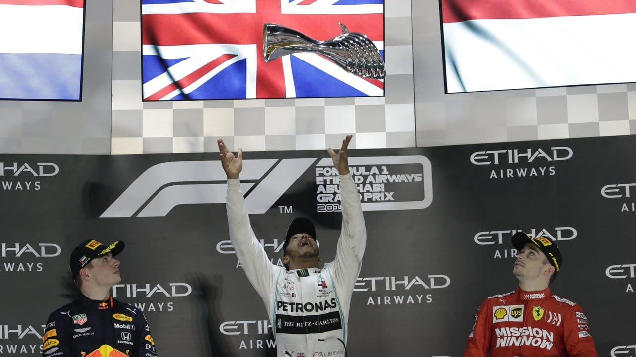Sieger Lewis Hamilton (M) wirft den Pokal zwischen Max Verstappen (l) und Charles Leclerc in die Höhe.