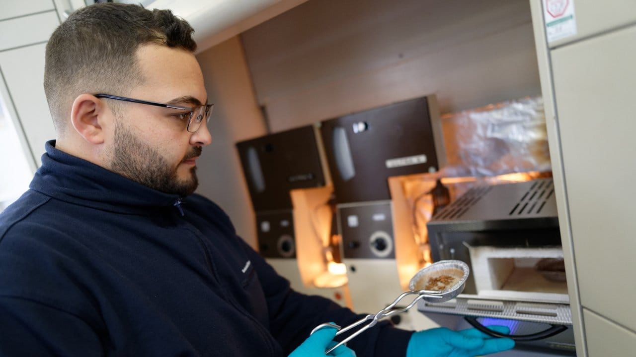 Auch Proben des Klärschlamms werden untersucht: David Uweis, angehende Fachkraft Abwassertechnik, legt im Labor der Kläranlage in Bonn-Duisdorf einen Behälter mit Proben in den Ofen.