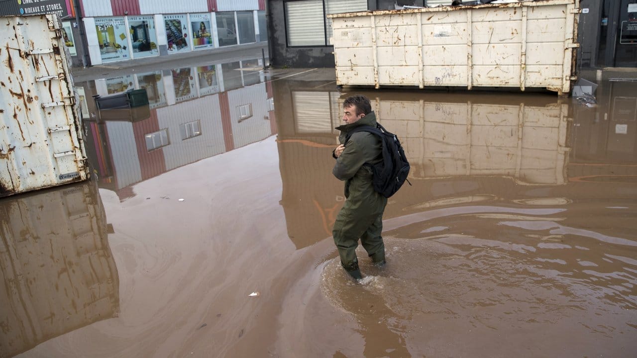 Ein Mann watet durch Hochwasser in der Stadt im Département Var.