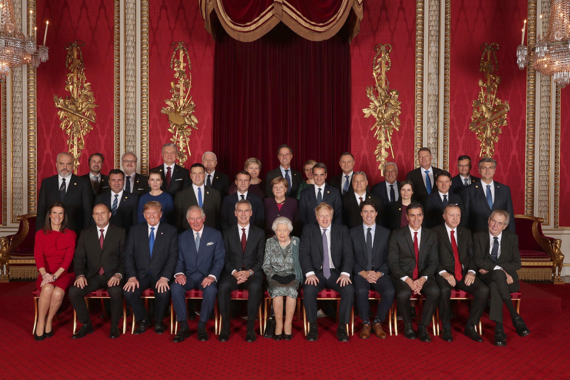 Die Staats- und Regierungschefs der Nato-Bündnisländer sitzen während eines Empfangs im Buckingham-Palast mit ihren Gastgebern für ein Gruppenfoto zusammen.