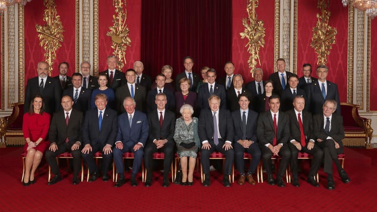 Die Staats- und Regierungschefs der Nato-Bündnisländer sitzen während eines Empfangs im Buckingham-Palast mit ihren Gastgebern für ein Gruppenfoto zusammen.