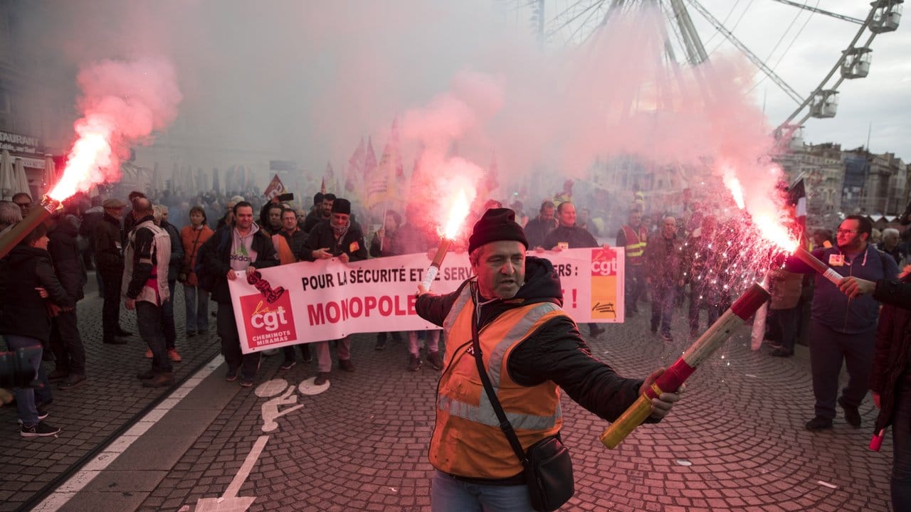 Ein Eisenbahner hält Fackeln während eines Streiks im Alten Hafen von Marseille.