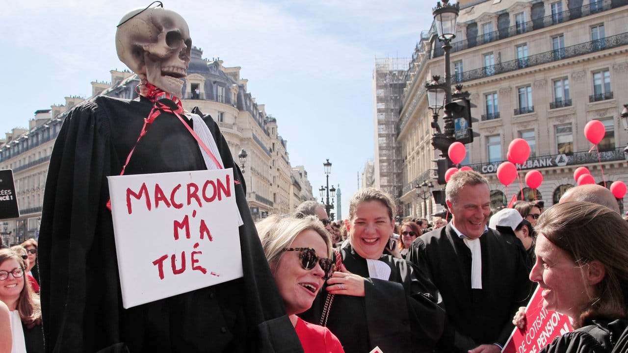 Protest in Paris: Ein Skelett in einer Richterrobe und einem Schild mit der Aufschrift "Macron hat mich getötet".