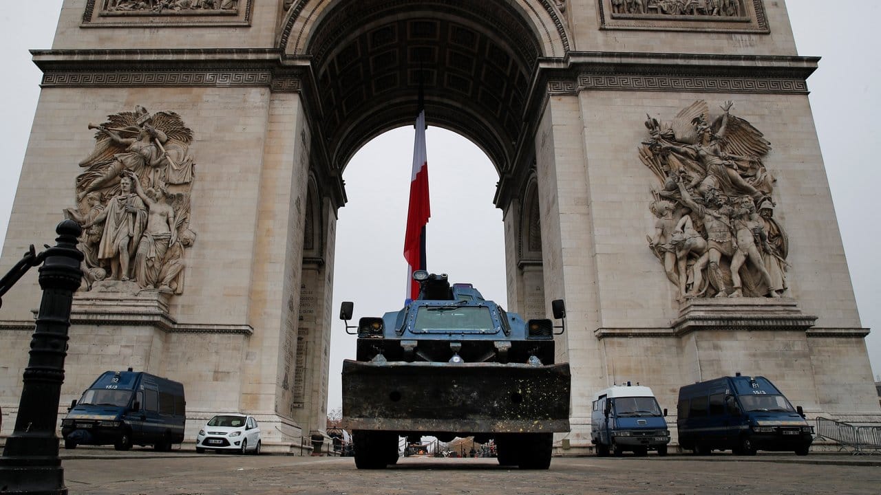 Polizeifahrzeuge parken am Arc de Triomphe in Paris.