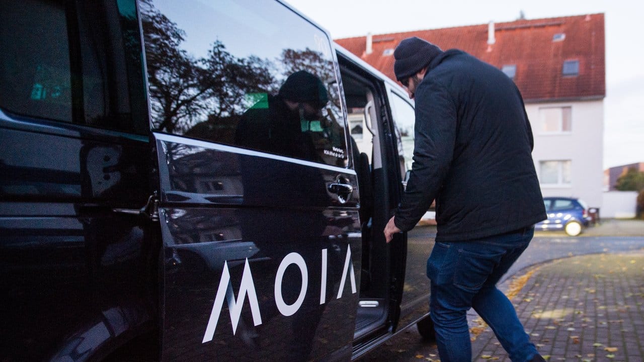 Ein Fahrgast betritt einen VW-Bus des Ridesharing-Anbieters MOIA.