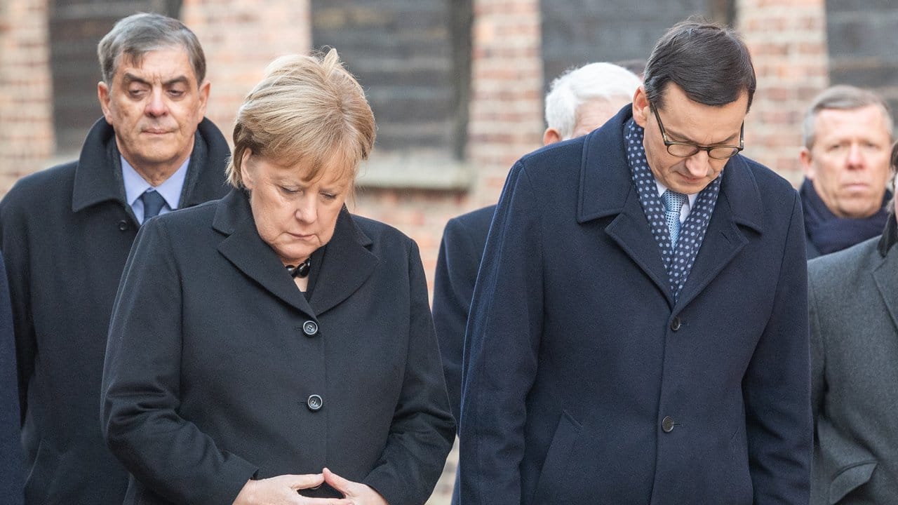 Bundeskanzlerin Angela Merkel (CDU) und Mateusz Morawiecki, Ministerpräsident von Polen, verneigen sich nach einer Kranzniederlegung im ehemaligen deutschen Konzentrationslager Auschwitz.
