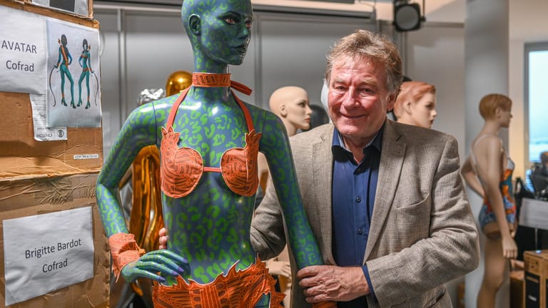 Alexander Ruscheinsky steht neben einer Puppe: Der Regensburger Unternehmer hält eine Avatar-Puppe mit einem Bikini fest.
