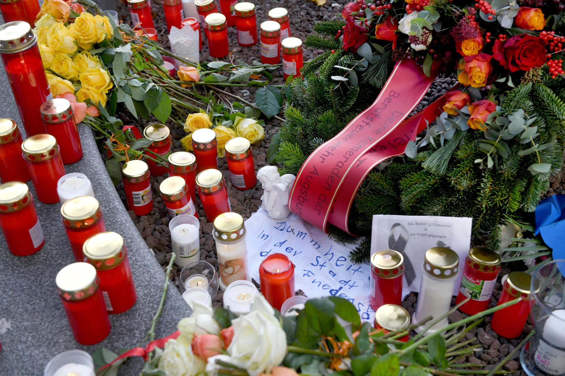 Blumen und Kerzen liegen in der Nähe des Tatorts: Der Königsplatz liegt mitten in Augsburg, der Bürgermeister sprach Angehörigen und Kollegen des Getöteten sein Mitgefühl aus.