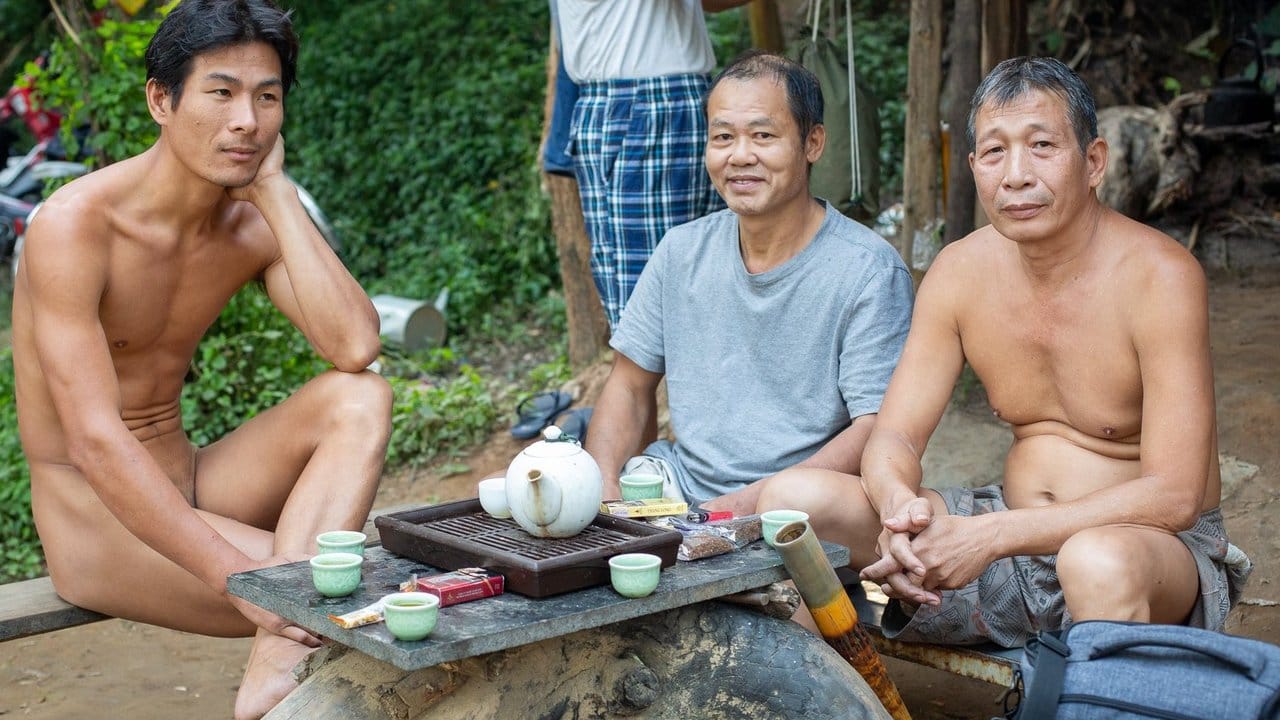 Duong (l) trinkt mit zwei Männern Tee.