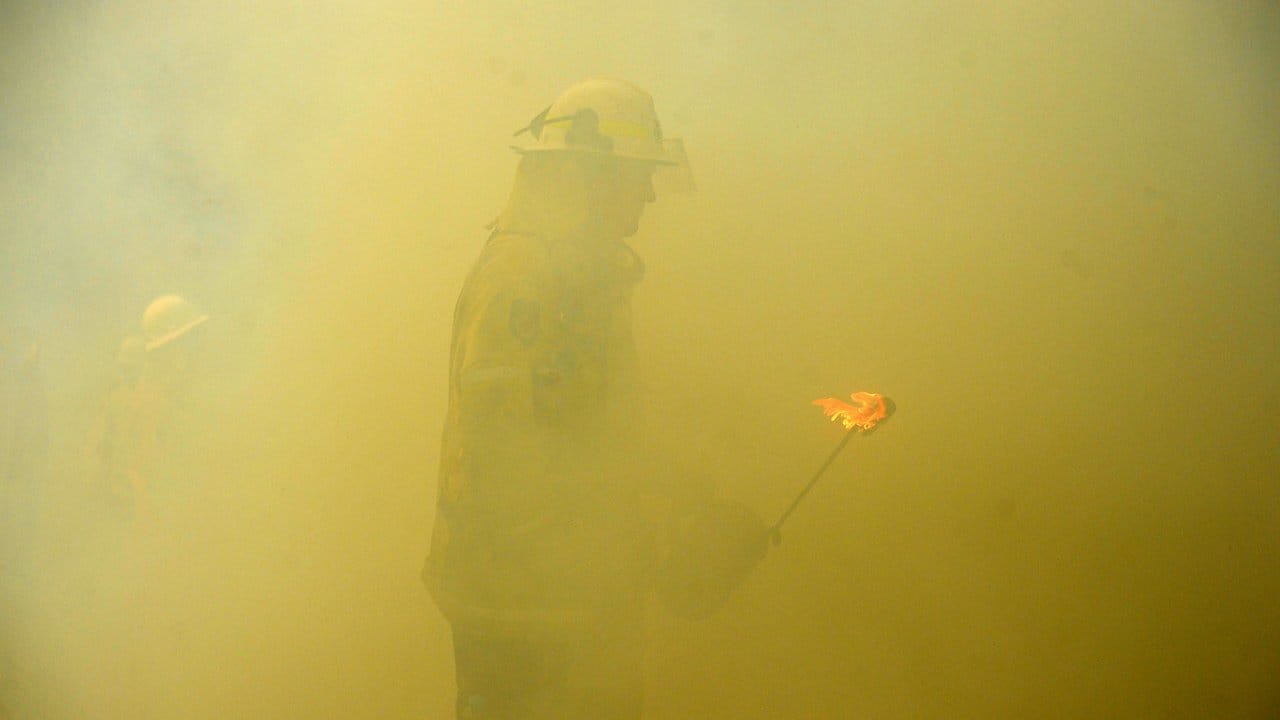 Um den Buschbränden im Osten Australiens Herr zu werden, legen Feuerwehrmänner Gegenfeuer.