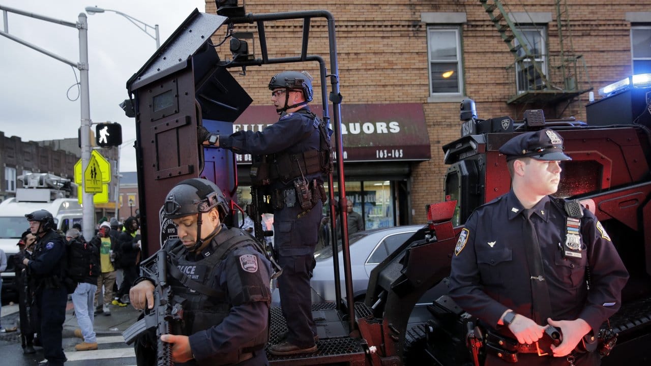 Schwer bewaffnete Polizisten sichern während der stundenlang andauernden Schießerei einen Straßenzug in Jersey City.