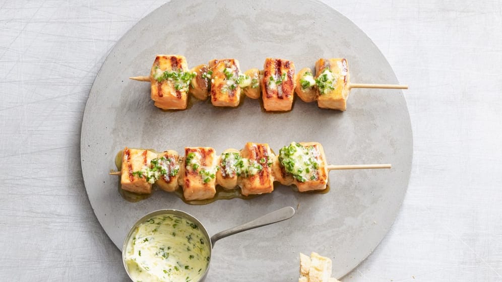 Spieße: Lachs- und Champignonwürfel werden zunächst in Zitronensaft, Olivenöl, Honig, Chilipulver und Salz mariniert und dann abwechselnd aufgespießt. Wenn sie von der Grillplatte kommen, lässt man Ingwerbutter darüber zergehen.