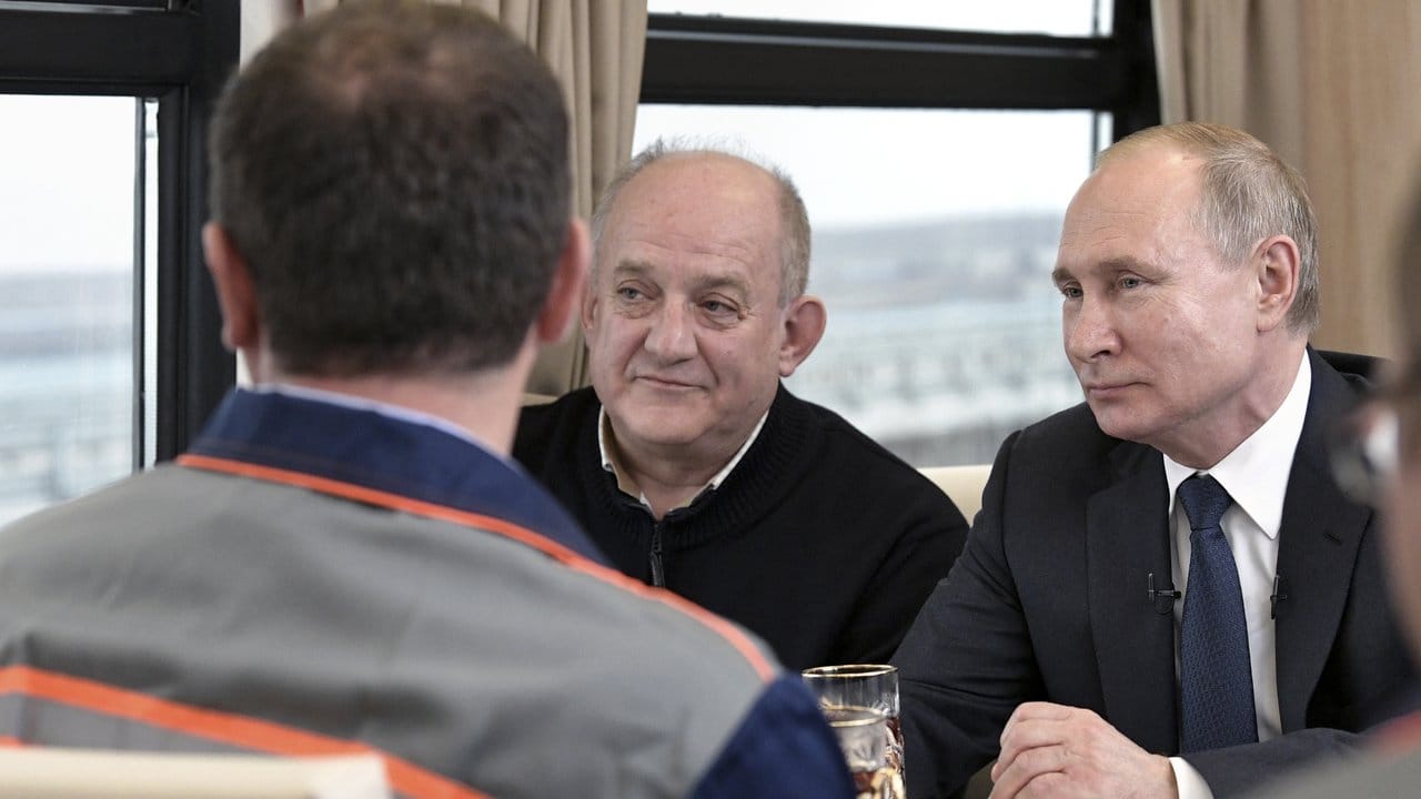 Der russische Präsident Wladimir Putin unterhält sich mit Arbeitern und Ingenieuren, während er per Zug über die neue 19 Kilometer lange Krim-Brücke fährt.